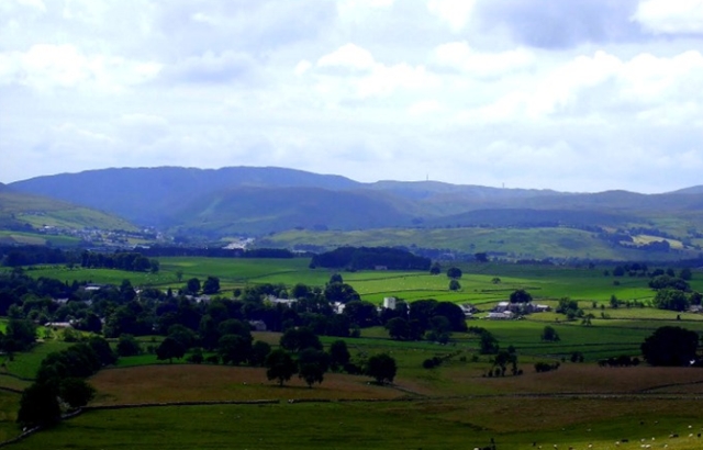 vast scene across a lush breen valley with hills